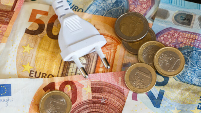 Euro coins, notes and electric plug