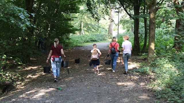 Teilnehmende des Dreck-weg-Tags tragen Eimer voller Müll. Foto: Christian Zimmer
