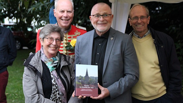 Pfarrer Ernst (Mitte) mit dem Buch über Kirchengeschichte, überreicht von Dorothea Stephan, Horst Osmann und Michael Stephan (vlnr.). Foto: Christian Zimmer