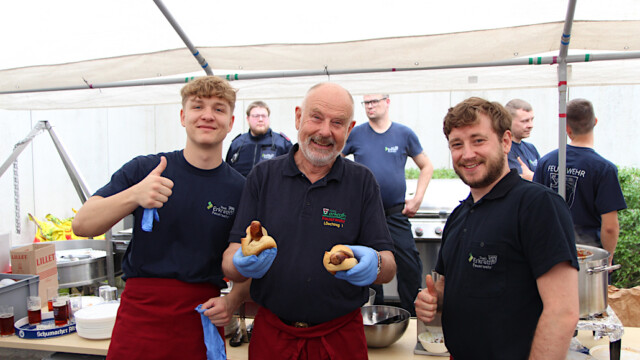 Mitglieder der Feuerwehr am Bratwurststand. Foto: Christian Zimmer